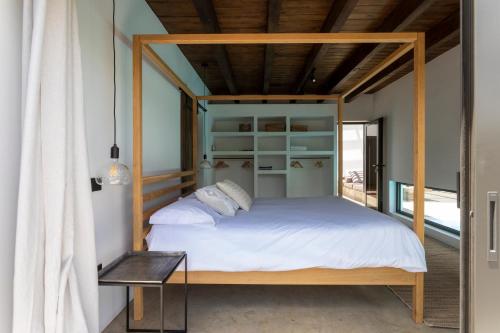 ein Schlafzimmer mit einem Bett mit einem hölzernen Baldachin in der Unterkunft Villa Borea - AlisiaFuerteventura in Villaverde