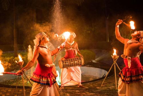 a group of women standing in front of a fountain with torches at Opulent River Face Hotel in Colombo