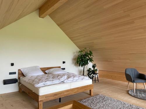 a bedroom with a bed and a wooden ceiling at Bummler Hof Allgäu in Legau