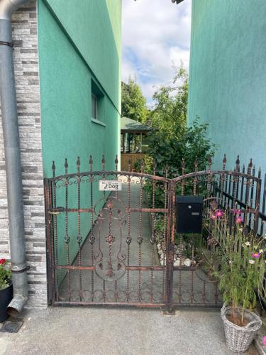 żelazną bramą przed zielonym budynkiem w obiekcie Apartment Rea Ilidža 2 w Sarajewie