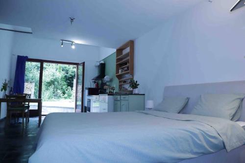 ein Schlafzimmer mit einem großen weißen Bett und einem Tisch in der Unterkunft Casa al Bosco in Gordevio