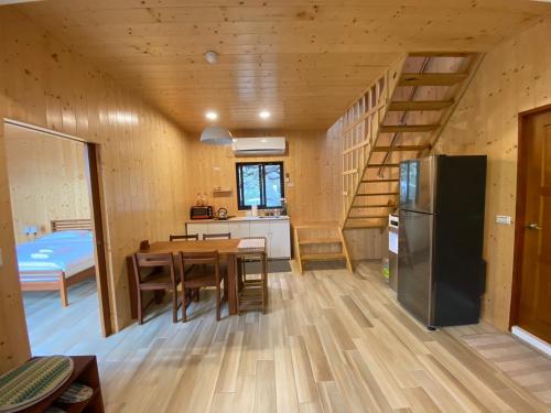 a kitchen and dining room with a table and a refrigerator at Clouds Camping House in Nanzhuang