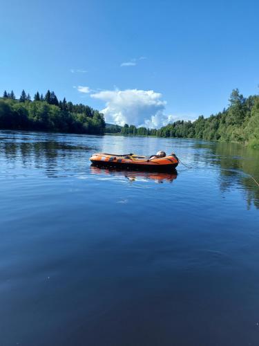 a red boat on a river in the water at Ferienhaus Segenäs Schweden in Stöllet