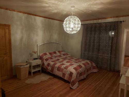 sypialnia z łóżkiem i żyrandolem w obiekcie Ferienhaus Segenäs Schweden w mieście Stöllet