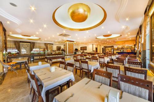 un restaurante con mesas y sillas en una habitación en Kleopatra Ada Hotel en Alanya