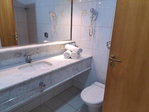 y baño con lavabo, aseo y espejo. en Hotel Michelangelo, en São José do Rio Preto