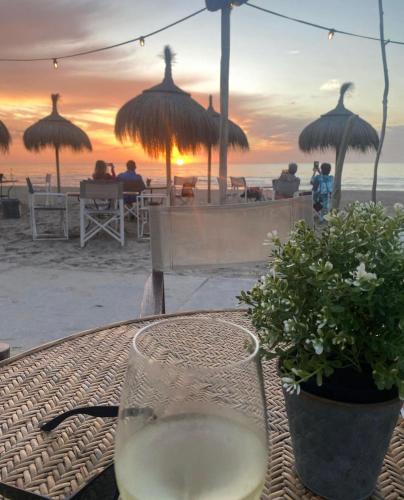 a glass of wine sitting on a table on the beach at Noordwijk BB228 in Noordwijk