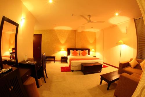 a hotel room with a bed and a couch at Opulent River Face Hotel in Colombo