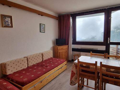 un salon avec un canapé, une table et une fenêtre dans l'établissement Studio agréable aux pieds des pistes avec balcon et animaux tolérés - FR-1-181-2591, à Aime La Plagne