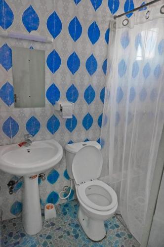 a blue and white bathroom with a toilet and sink at Mipeja Hotel in Busia