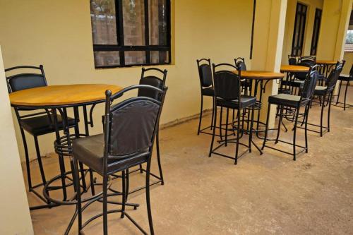 a group of tables and chairs in a room at Mipeja Hotel in Busia