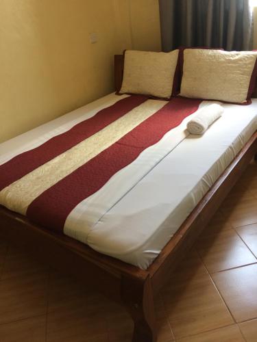 a large bed in a room with avertisementatronatronatronstrationstrationstrationstration at Mipeja Hotel in Busia