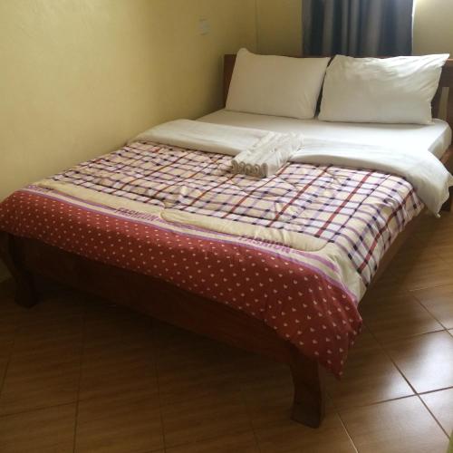 a bed with a quilt on top of it at Mipeja Hotel in Busia