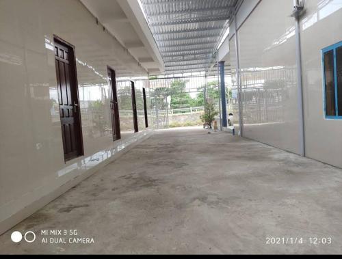 um corredor vazio de um edifício com portas de vidro em Nhà nghỉ La Gi em Tân Tạo