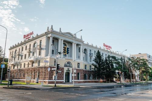 ein großes weißes Gebäude an der Ecke einer Straße in der Unterkunft Ramada by Wyndham Astana in Astana