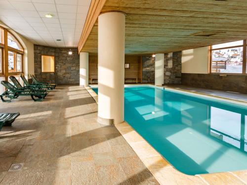 - une grande piscine dans un bâtiment doté d'un plafond en bois dans l'établissement Spacious apartment 500 m from the slopes of Les Sybelles, à La Toussuire