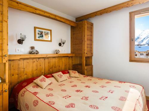 a bedroom with a bed and a window at Ski Getaway with Shared Pool in La Toussuire