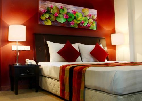 a bedroom with a bed with a painting on the wall at Opulent River Face Hotel in Colombo
