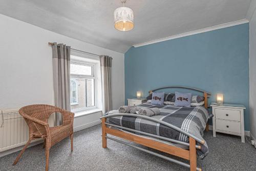 a bedroom with a bed and a chair and a window at Ger y Bae sleeps 10 in Cemaes Bay