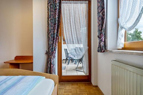 a bedroom with a bed and a window with a chair at Drei-mädelhaus Ambs Wohnung 1 in Ravensburg