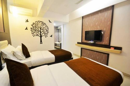 a hotel room with two beds and a tv at AN STAYS Chennai Airport in Chennai