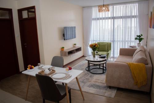 a living room with a couch and a table at Egoli Premiere Serviced Apartments by Nest & Nomad in Nairobi