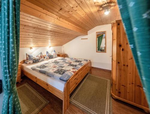 um quarto com uma cama num chalé de madeira em Landhaus Braun em Mittenwald