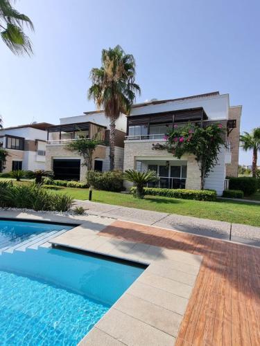 a house with a swimming pool in front of a house at The Valley 2 bedroom Apartment in Side