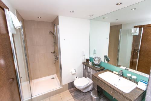 a bathroom with a toilet and a sink and a shower at Hilton London Canary Wharf in London