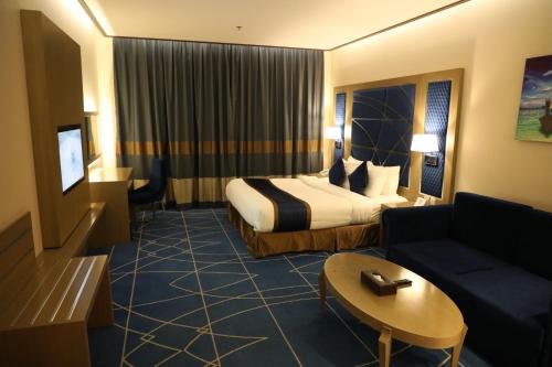 een hotelkamer met een bed en een bank bij Best Level Hotel in Jeddah