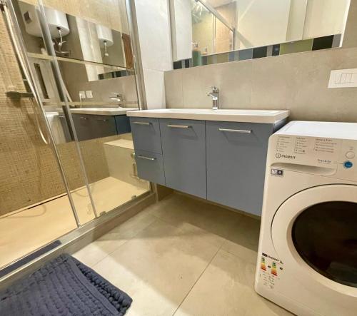 ein Badezimmer mit einer Waschmaschine und einem Waschbecken in der Unterkunft Sunset by Connexion in Cannes