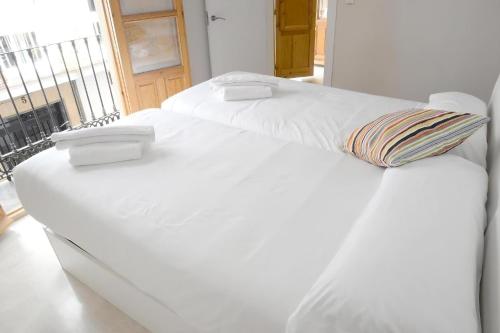 Apartamentos Comfort City في غرناطة: سريرين بيض في غرفة مع نافذة