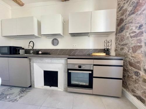 une cuisine avec des armoires blanches et un four à plaques de cuisson dans l'établissement Sunset by Connexion, à Cannes