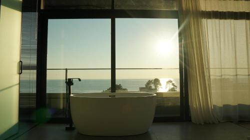 a bath tub in a room with a large window at Hotel Nobilis Hall in K'obulet'i