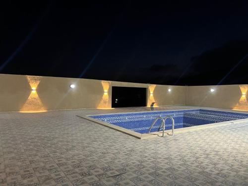 a swimming pool in a building at night at Gernatah Farm مزرعة غرناطه in Ajloun