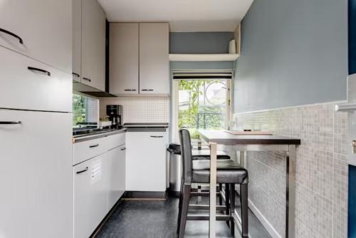 a kitchen with white cabinets and a table and chairs at Sky Villa in Bergschenhoek
