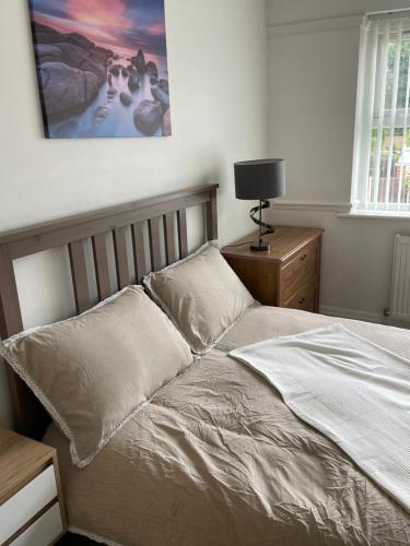uma cama num quarto com uma fotografia na parede em The broadway house em Walsall