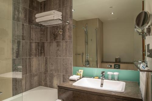 a bathroom with a sink and a shower at Hilton London Canary Wharf in London