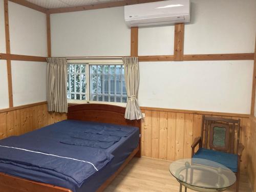 1 dormitorio con 1 cama, 1 silla y 1 ventana en 夏綠房, en Fengyuan