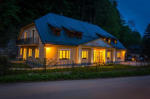 a white house with a blue roof at night at Apartmány Weissov Dom in Banská Štiavnica