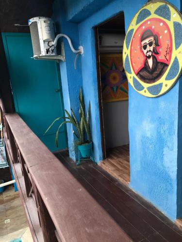 a room with a blue wall with a painting on the wall at Pousada Alto Astral in Olinda