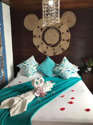 a bedroom with a bed with a chandelier at Pousada Alto Astral in Olinda