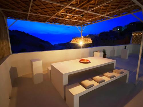 um quarto com uma mesa com almofadas e uma luz em Entire house with private rooftop em Al Hoceïma