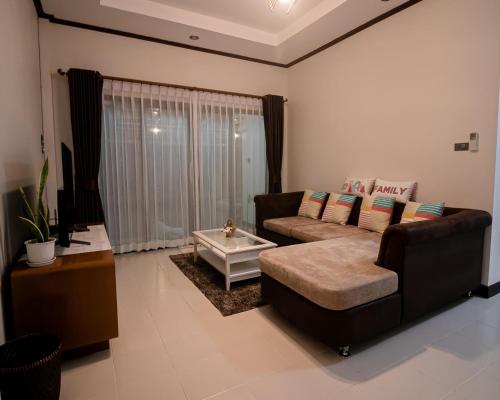 uma sala de estar com um sofá e uma mesa de centro em BannPordee em Nakhon Si Thammarat