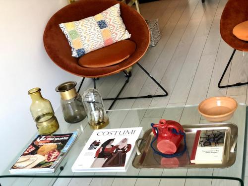 a glass table with a chair and books on it at TigellioTre Bed and Breakfast in Cagliari