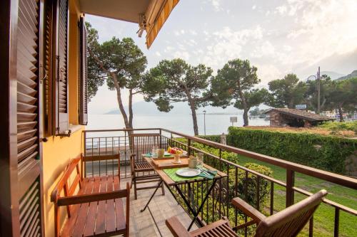 a balcony with a table and chairs and a view of the water at Appartamento Lungolago in Domaso