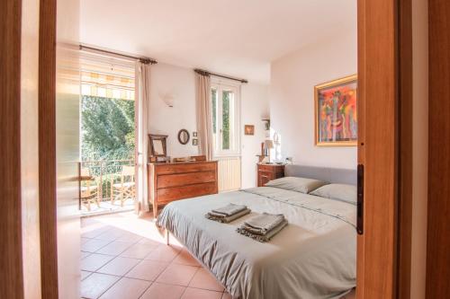 a bedroom with a bed and a large window at Appartamento Lungolago in Domaso