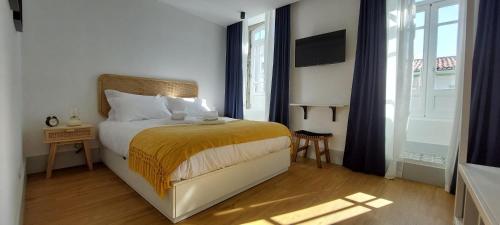 a bedroom with a bed and a large window at Angra Heritage - City Center Hostel in Angra do Heroísmo