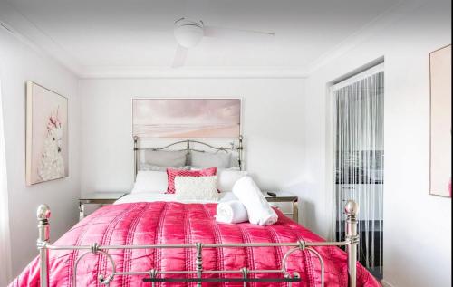 a bedroom with a large bed with a red blanket at Beachside Beauty at Burleigh Pavilion! in Gold Coast