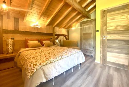 um quarto com uma cama num quarto com paredes de madeira em Le P'tit Curieux em Rupt-sur-Moselle